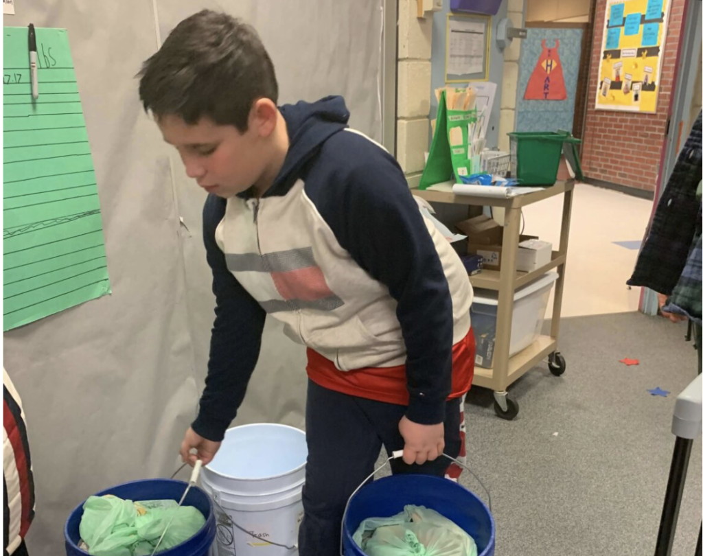 A student with two compost buckets